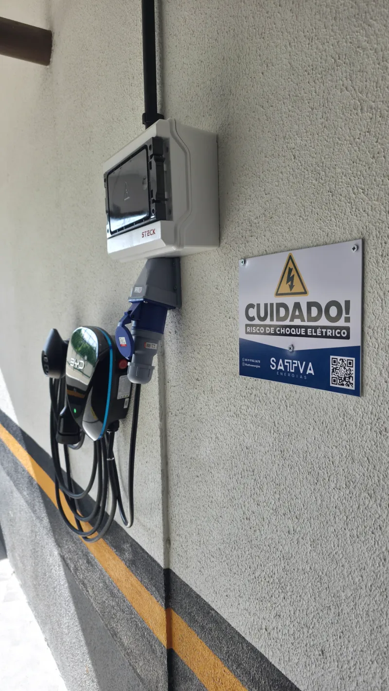 Carregador veicular instalado em garagem, com cabo de recarga enrolado