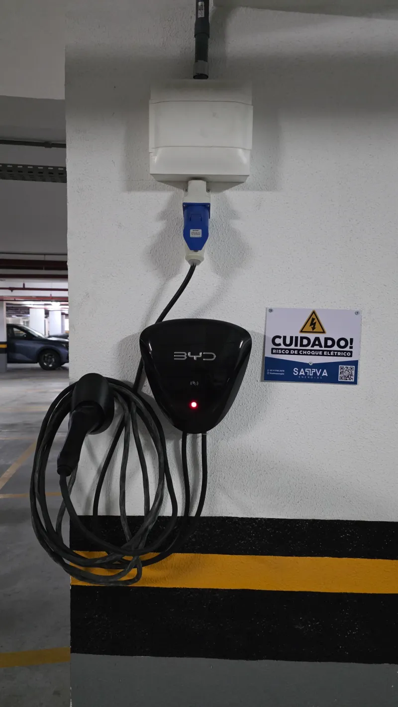 Carregador de carro elétrico instalado em garagem de subsolo, com veículo ao fundo