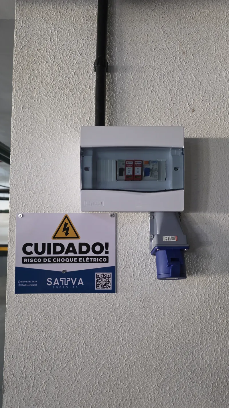 Quadro elétrico e tomada industrial instalados em garagem, com veículo ao fundo